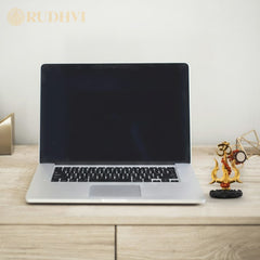 Laptop on a wooden desk with shiv shakti trishul. 