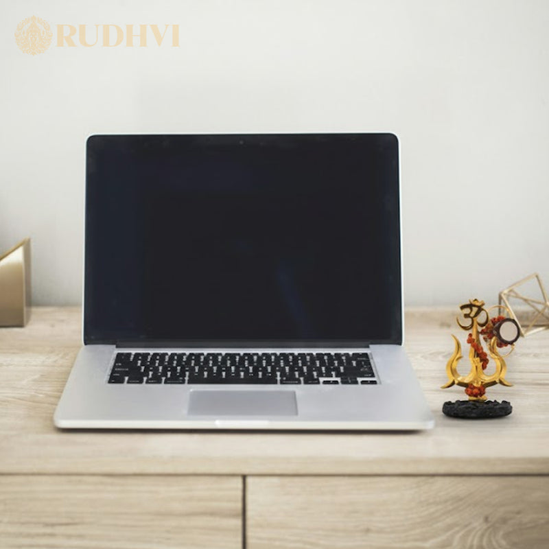 Laptop on a wooden desk with shiv shakti trishul. 