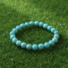 Turquoise (Firoza) Healing Bracelet by Rudhvi placed on green grass – natural gemstone bracelet for peace and positivity