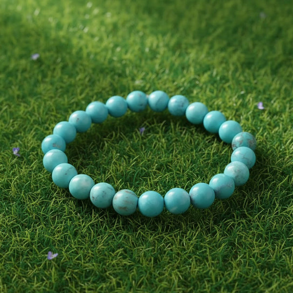 Turquoise (Firoza) Healing Bracelet by Rudhvi placed on green grass – natural gemstone bracelet for peace and positivity