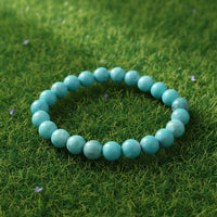 Turquoise (Firoza) Healing Bracelet by Rudhvi placed on green grass – natural gemstone bracelet for peace and positivity